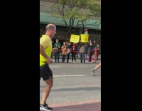 People in crowd of NYC marathon holding signs 