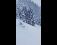 man snow boarding brown pants spins falls in snow