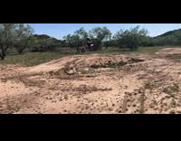 Little boy rides red motorcycle over dirt 