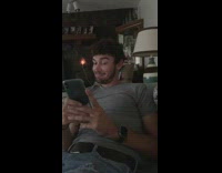 Guy looking at phone grey shirt puts it down