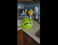 Face drawn on green balloon pops blue 