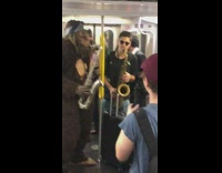Bigfoot in blue bandana plays saxophone with guy on the subway train, drops sunglasses