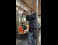 Guy plays trumpet on train into mic 
