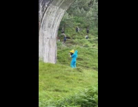 Man in a blue screen lifts baby under the bridge