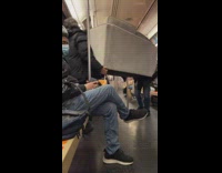 Two guys carry couch off train
