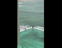 Woman edge of pool waves crashing