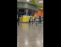 Man yells while he exercise in the gym while man films him