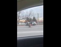 Guy drives atv on parkway stand trick