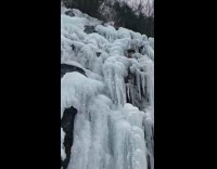 Water flows down cliff covered in icicles  