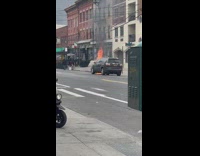 black car with hood on fire motorcycles stop to watch