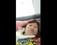 Cat laying on lady sucks her ear