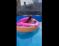 Kid floating on inflatable donut with dog