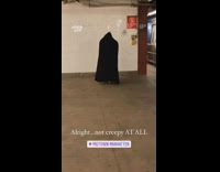 Person wears black cape robe with hood