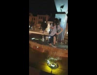 Guy tries to get out of water fountain but trips and falls face first