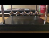 Guy turns newtons cradle balls hit middle 