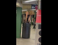 Guy in rat costume squats on subway trashcan 