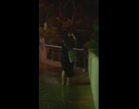 Woman in black dress take pictures in a storm