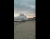 White grey smoke from fire beach sunset