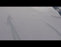 Guy rides skis down mountain fresh snow 