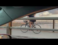 Guy on bike has little white dog on back