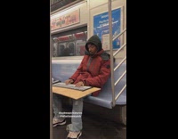 Guy playing piano on rollout keyboard on subway