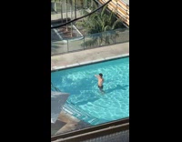 Man shirtless flexes his muscle on the swimming pool
