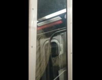 man smokes between subway cars