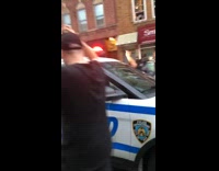 Peaceful protest people march by NYPD car 
