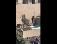 Woman in dress turn pose beside pool