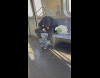 A man in blue hoodie smoking in train