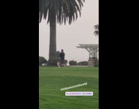Man practices fighting next to two women