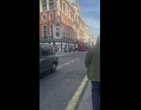 Girls stand on road divider with tripod 