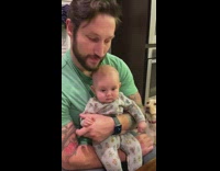 Dad brushes baby head with beard