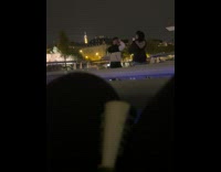 Man in black and white jacket poses beside the boat railings