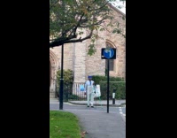 Man blue hat films front of church