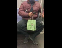 Guy on subway holding weed world bag 