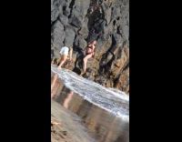 Collab IITW - Woman black bikini dances by beach rock