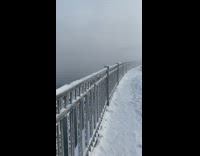 Scenery view of a snow covered bridge and hazy fog over the water 

