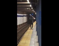 Guy carrying pair of skis walks subway 