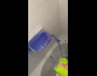 Cleaning bathroom tub with purple and blue liquid and powder