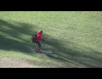 Red jacket guy rides skis grass dirt 