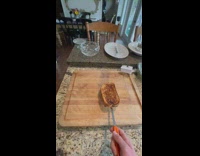 Spatula flips garlic bread on cutting board and catches it 