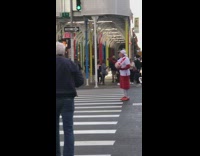Man red shorts hold up soccer ball in air in the middle of street 