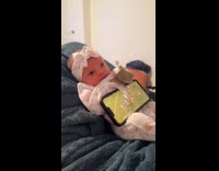 Dad uses newborn as phone holder 