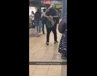 Guy dances and his backpack starts to fall off his shoulder in subway station