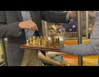 Two guys stand play chess subway train