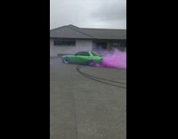Green car drifts with pink smoke 