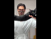 Man dancing while carrying cat 