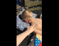 Boy facedown on blue pillow trampoline backyard 