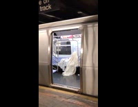 Collab WINY - Man under white blanket in subway train